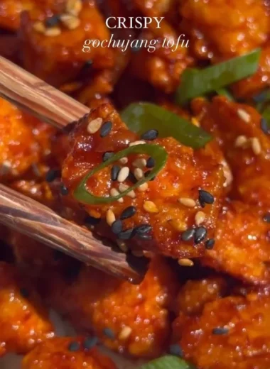 Delicious Gochujang Tofu dish garnished with fresh vegetables and spices.