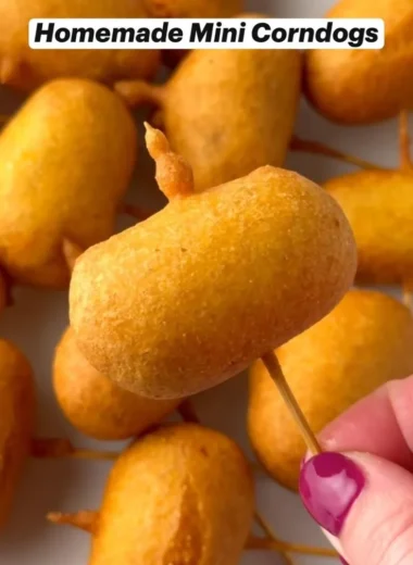 Homemade mini corndogs served on a plate with dipping sauce