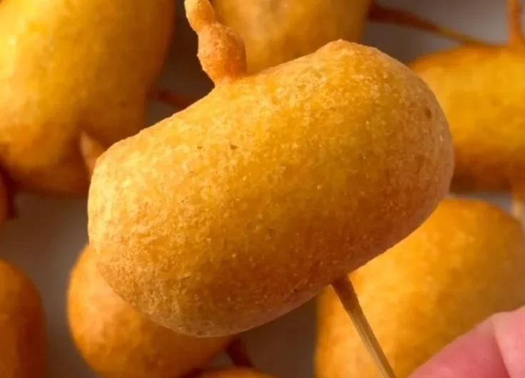 Homemade mini corndogs served on a plate with dipping sauce
