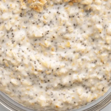 Coconut Cream Pie Overnight Oats in a bowl topped with coconut flakes and fruit.