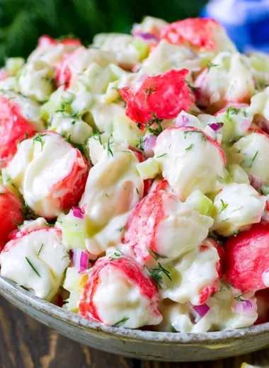 Delicious crab salad garnished with fresh herbs and served in a bowl.