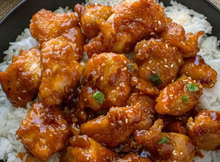 Plate of General Tso's Chicken garnished with sesame seeds and scallions