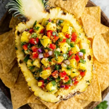 Bowl of fresh pineapple salsa with cilantro, lime, and red onion.
