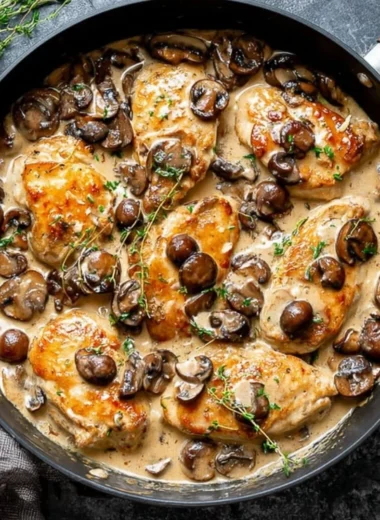Skillet Chicken with Mushroom Wine Sauce plated with herbs and side veggies