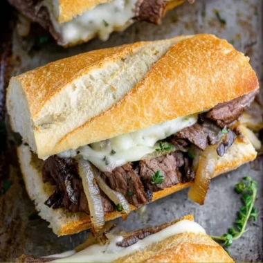 Delicious steak sandwiches with toppings and condiments on a wooden board.
