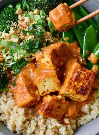 Cozy Thai Peanut Tofu Quinoa Bowl with fresh vegetables and rich peanut sauce