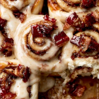 Bourbon Maple Bacon Cinnamon Rolls topped with maple glaze and crispy bacon.