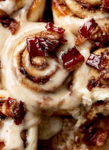 Bourbon Maple Bacon Cinnamon Rolls topped with maple glaze and crispy bacon.