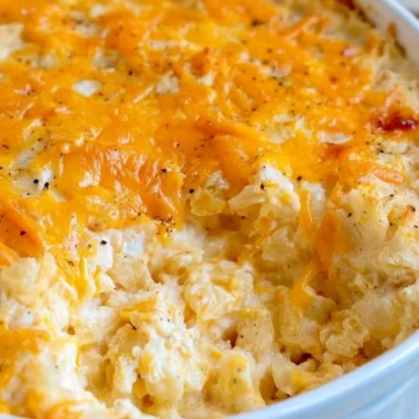 Cheesy hashbrown casserole topped with melted cheese and crispy edges
