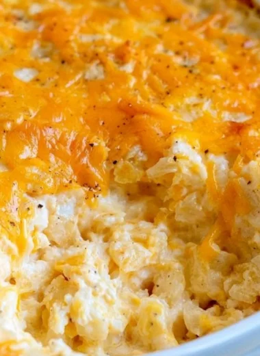 Cheesy hashbrown casserole topped with melted cheese and crispy edges