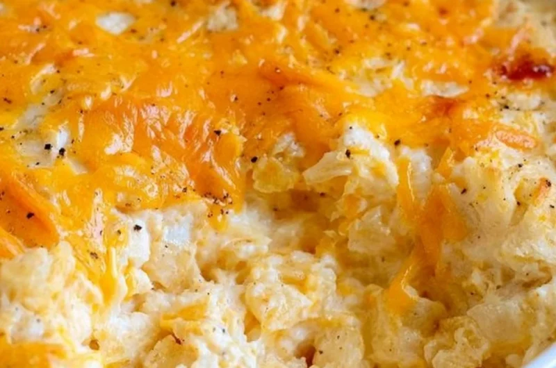 Cheesy hashbrown casserole topped with melted cheese and crispy edges