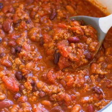 Bowl of healthy turkey chili topped with fresh herbs and served with cornbread.