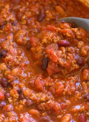 Bowl of healthy turkey chili topped with fresh herbs and served with cornbread.