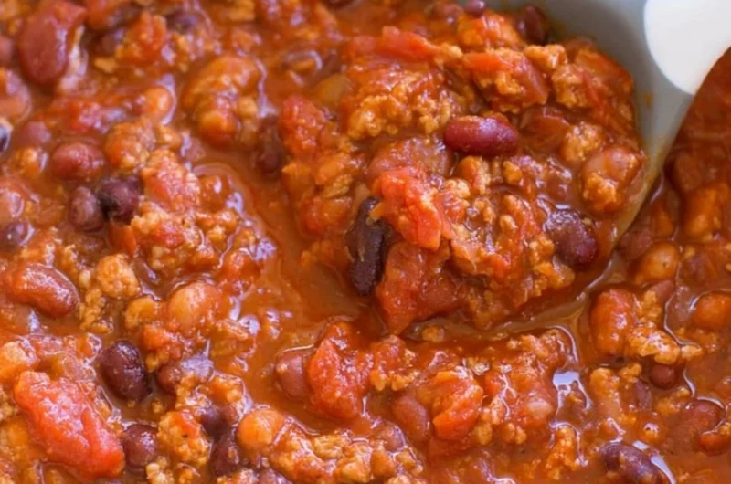 Bowl of healthy turkey chili topped with fresh herbs and served with cornbread.