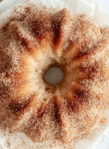 Delicious slice of cozy Apple Cider Donut Cake topped with cinnamon sugar