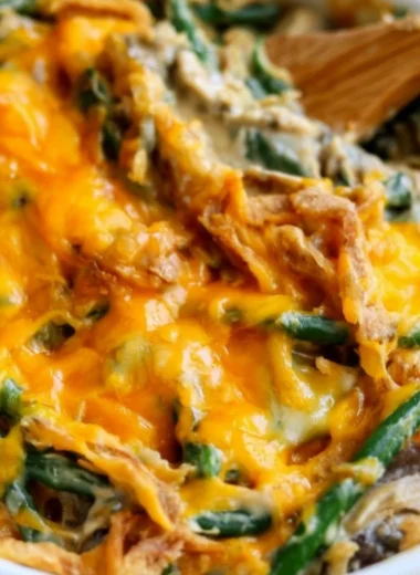 Cozy green bean casserole topped with crispy onions and creamy sauce in a baking dish