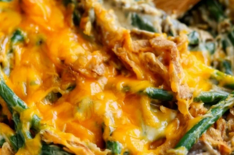 Cozy green bean casserole topped with crispy onions and creamy sauce in a baking dish