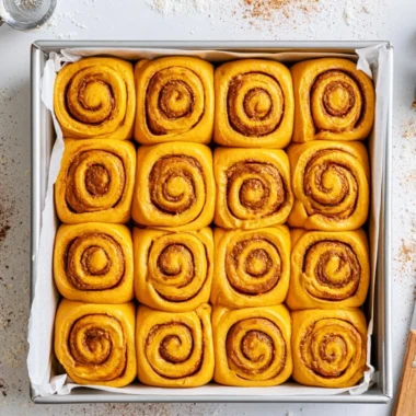Freshly baked Pumpkin Cinnamon Rolls topped with cream cheese icing