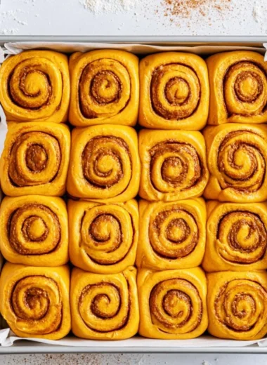 Freshly baked Pumpkin Cinnamon Rolls topped with cream cheese icing