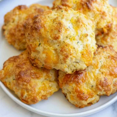Freshly baked sourdough cheddar biscuits on a cooling rack