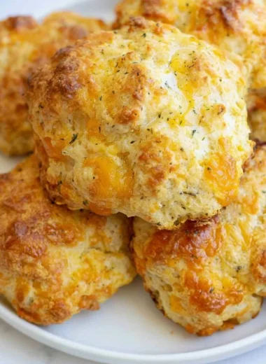 Freshly baked sourdough cheddar biscuits on a cooling rack