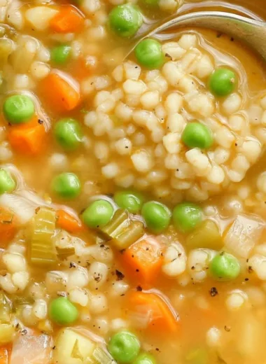 Bowl of hearty veggie barley soup with fresh vegetables and barley grains