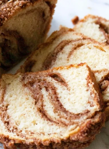 Slice of cozy cinnamon swirl vanilla pound cake on a plate