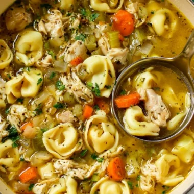 Bowl of cozy chicken tortellini soup garnished with herbs
