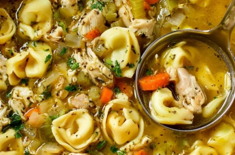 Bowl of cozy chicken tortellini soup garnished with herbs