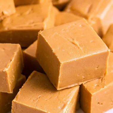 Creamy peanut butter fudge dessert topped with chocolate and nuts.
