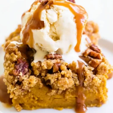Delicious Pumpkin Pie Crunch Cake topped with a crunchy layer and whipped cream