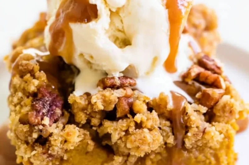 Delicious Pumpkin Pie Crunch Cake topped with a crunchy layer and whipped cream