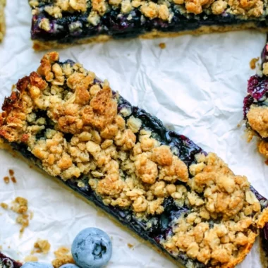 Brown sugar oatmeal breakfast bars with fresh blueberries on a plate.