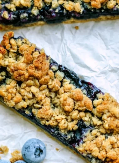 Brown sugar oatmeal breakfast bars with fresh blueberries on a plate.