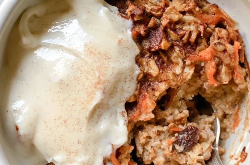 Delicious Carrot Cake Baked Oatmeal served in a bowl with oats and carrot shavings.