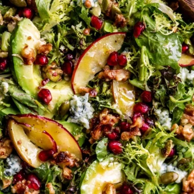 Colorful Christmas Salad topped with honey mustard dressing in a festive bowl.