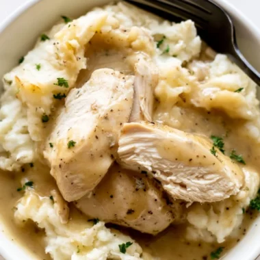 Instant Pot Chicken and Gravy served in a bowl with herbs and spices